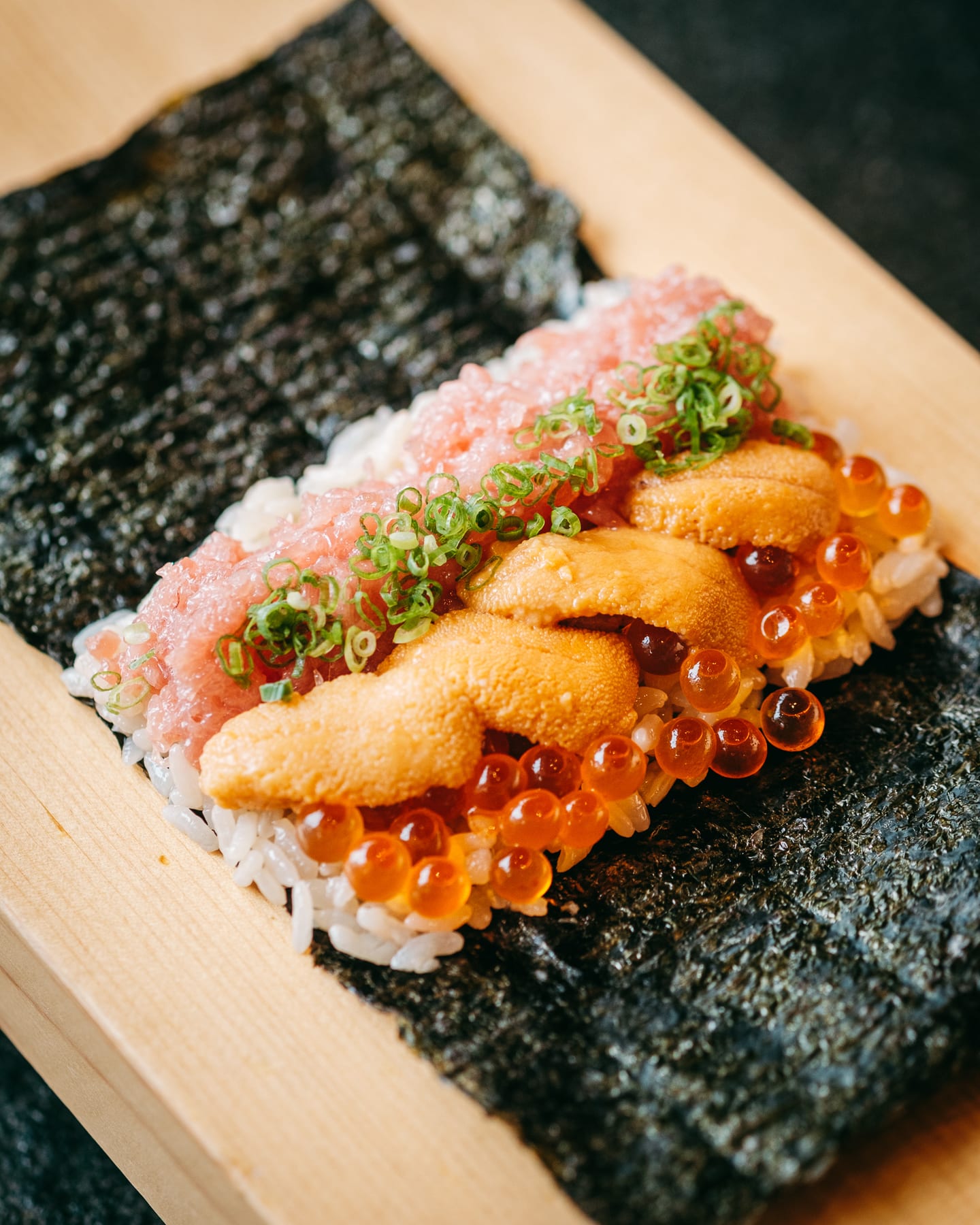 A freshly made handroll passed across the Momiji counter